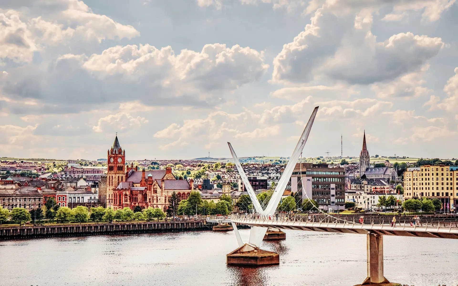 Derry's Peace Bridge over the River Foyle with the Guildhall and St Eugene's Cathedral behind